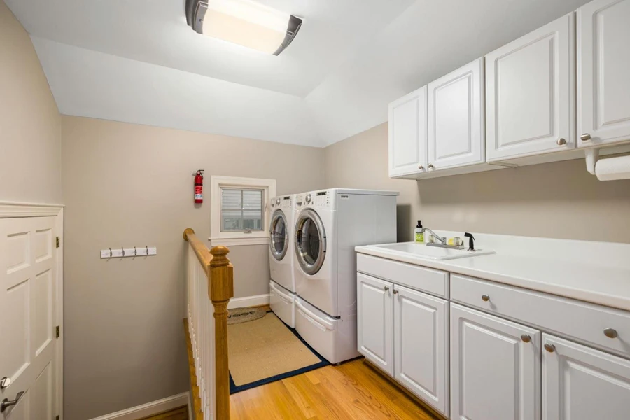 White cabinets and a side-by-side washer and dryer set