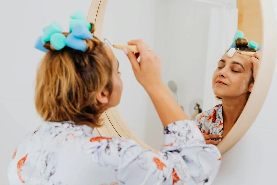 Woman Doing Skin Care by Mirror