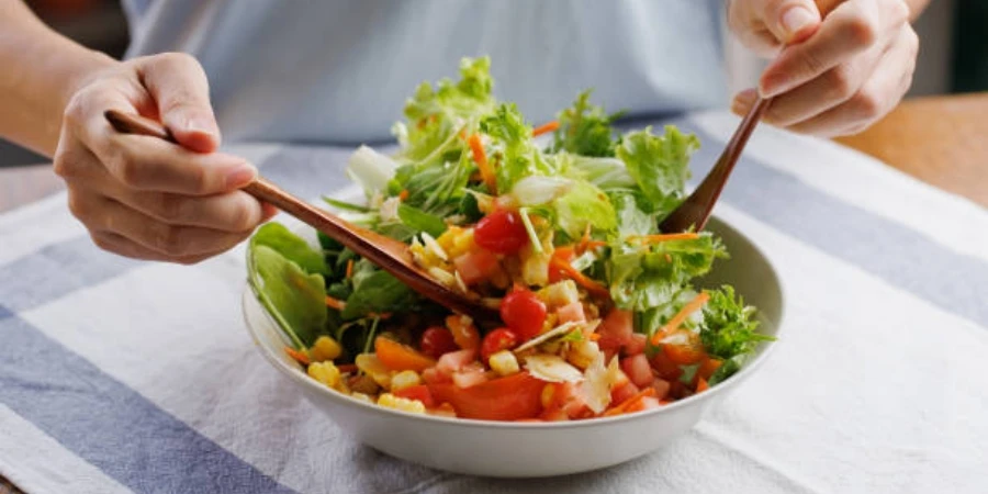 Woman Mixing Ingredients in Her Healthy Fresh Vegan Salad