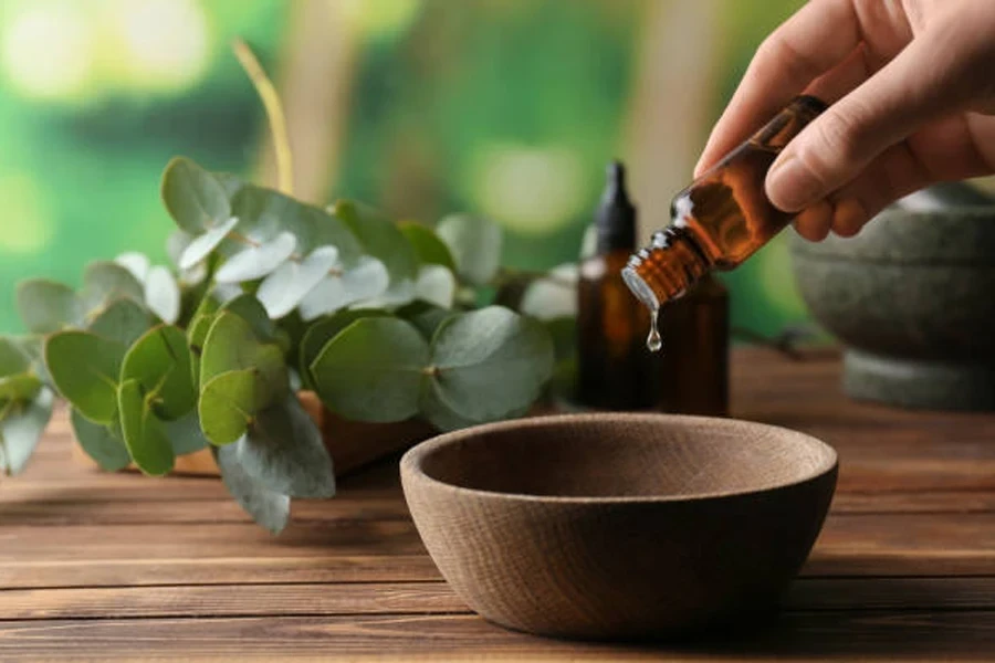 Woman Pouring Eucalyptus Essential Oil into Bowl