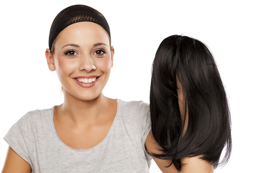 Mujer sosteniendo una gorra de peluca