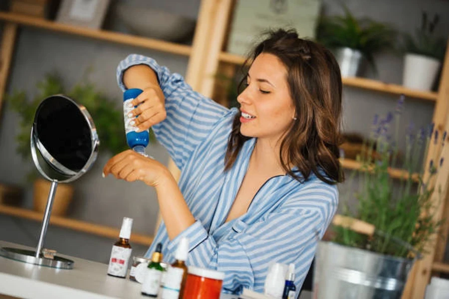 Woman using moisturizing hand cream in front of mirror