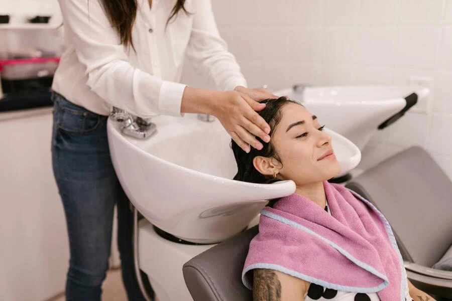 Woman washing her hair in a sink