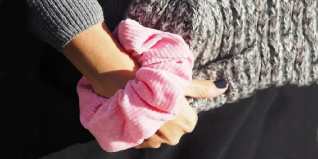 Woman wearing pink corduroy scrunchie on wrist