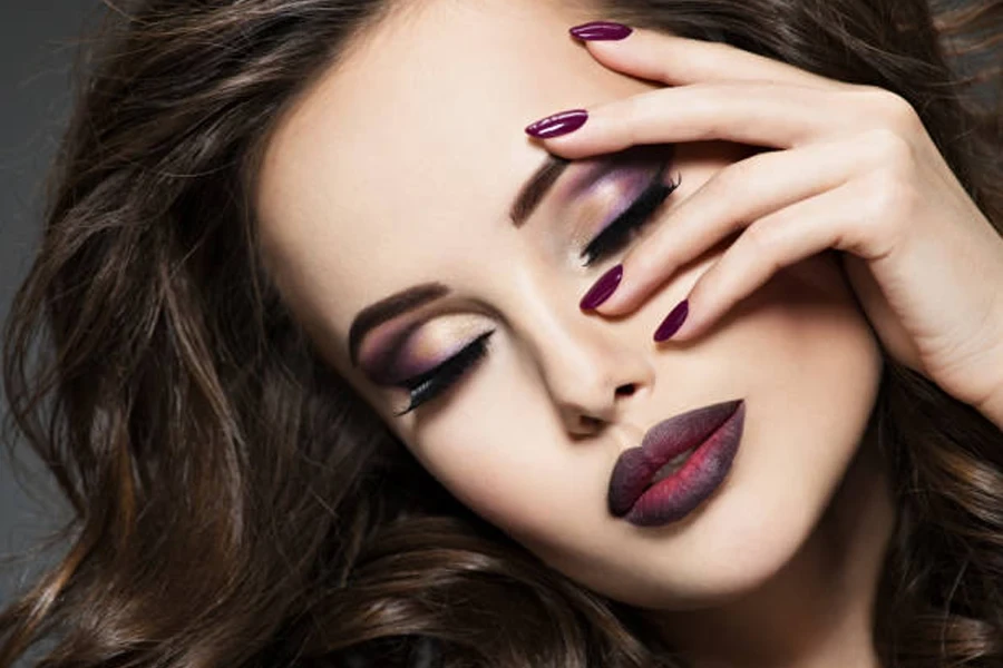 Woman with brown hair wearing bold burgundy lipstick