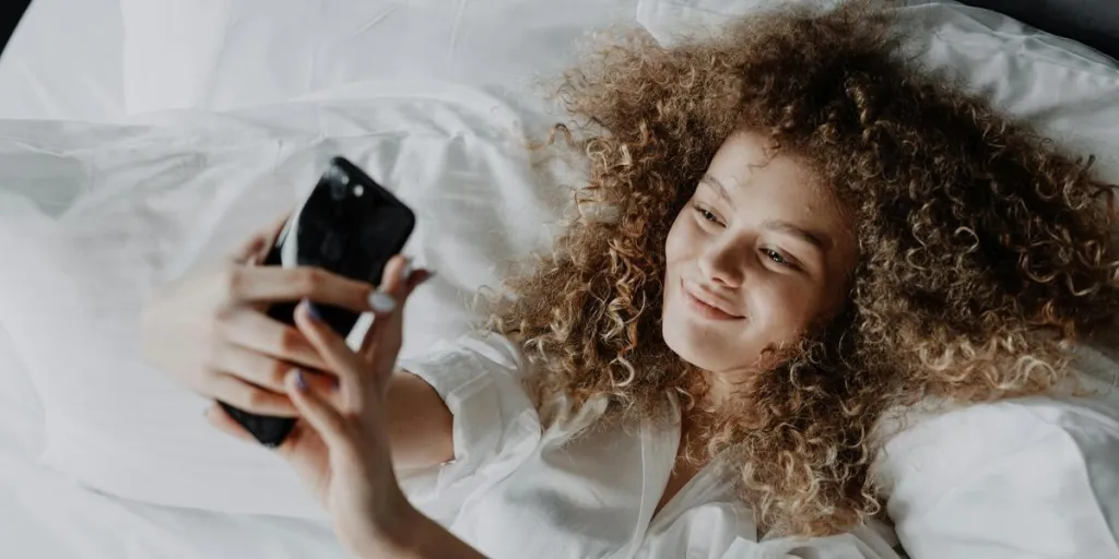 Woman with curly hair lying in bed