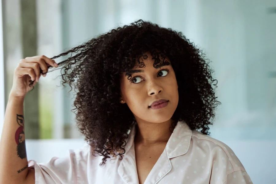 Woman with curly hair stretching out her hair