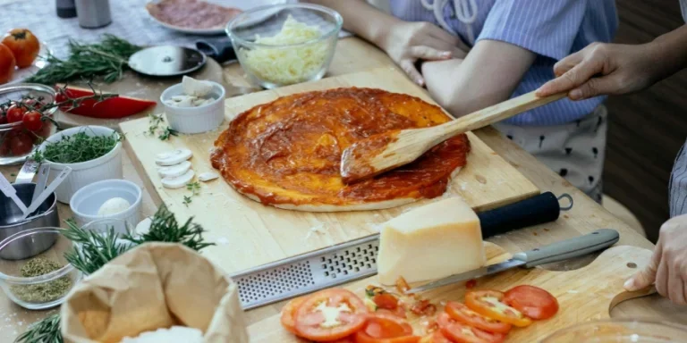 Women in the process of preparing homemade pizza