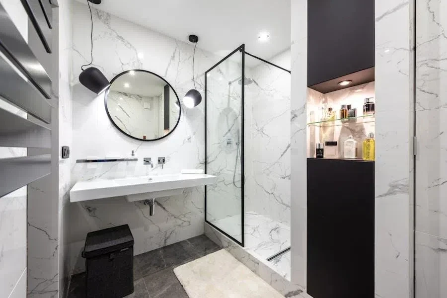 A black and white bathroom with a niche shelf and a marble shelf