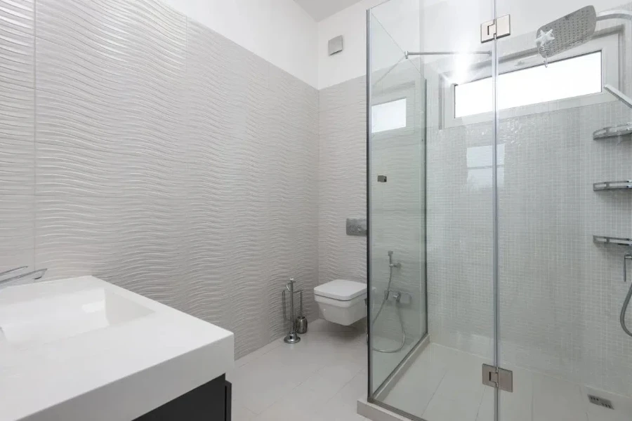 A full white bathroom with a see-through shower and corner shelves