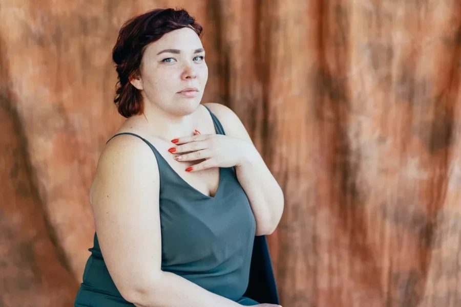 A plus-size woman in a green camisole