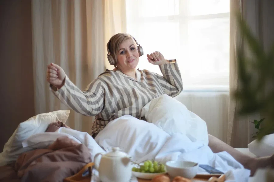 A plus-size woman in striped, long-sleeved sleep shirt