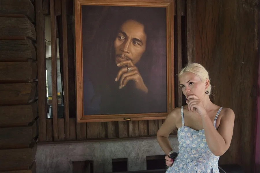 A woman with short hair standing near a painting