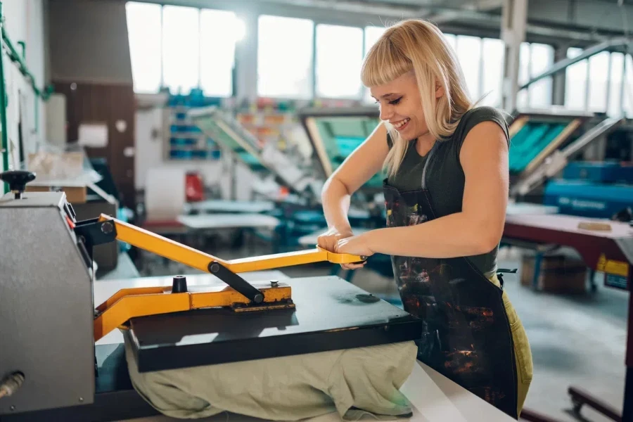 female graphic technology expert pressing heating press