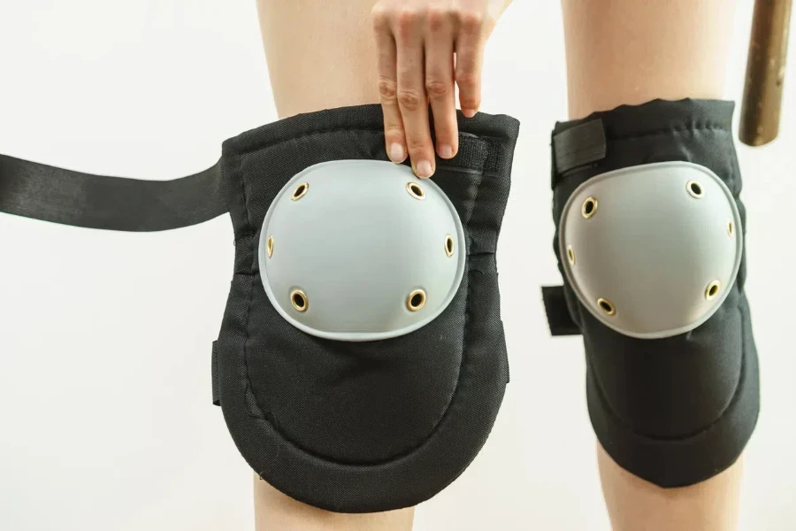 woman wearing and adjusting her safety knee protectors pads