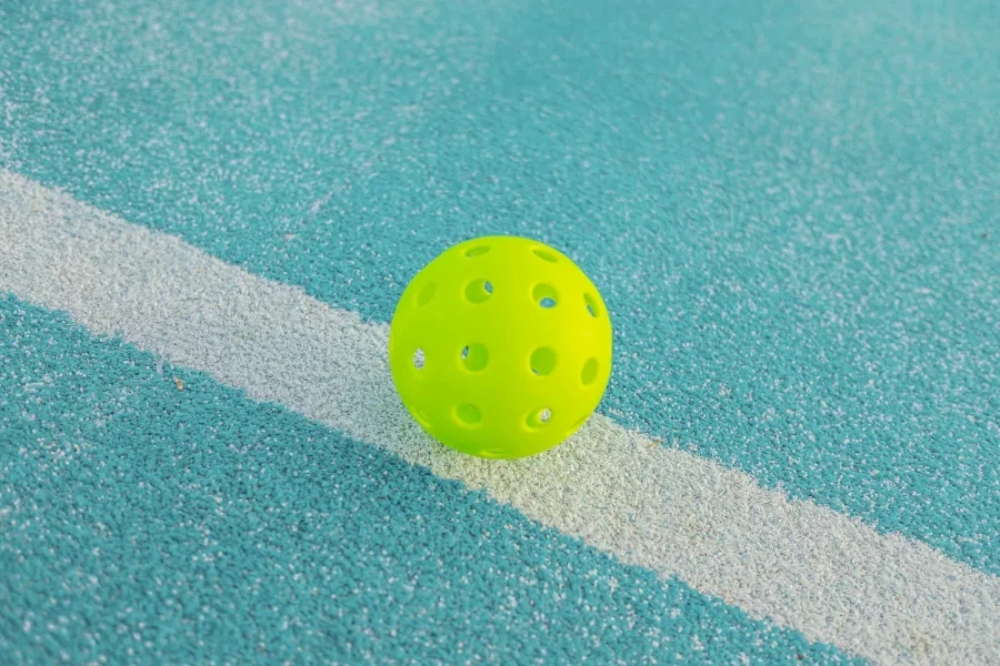 a pickleball on pickleball blue court line