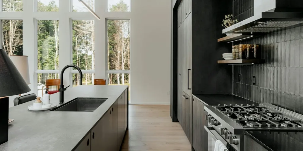 interior with black kitchen cabinets and dark backsplash