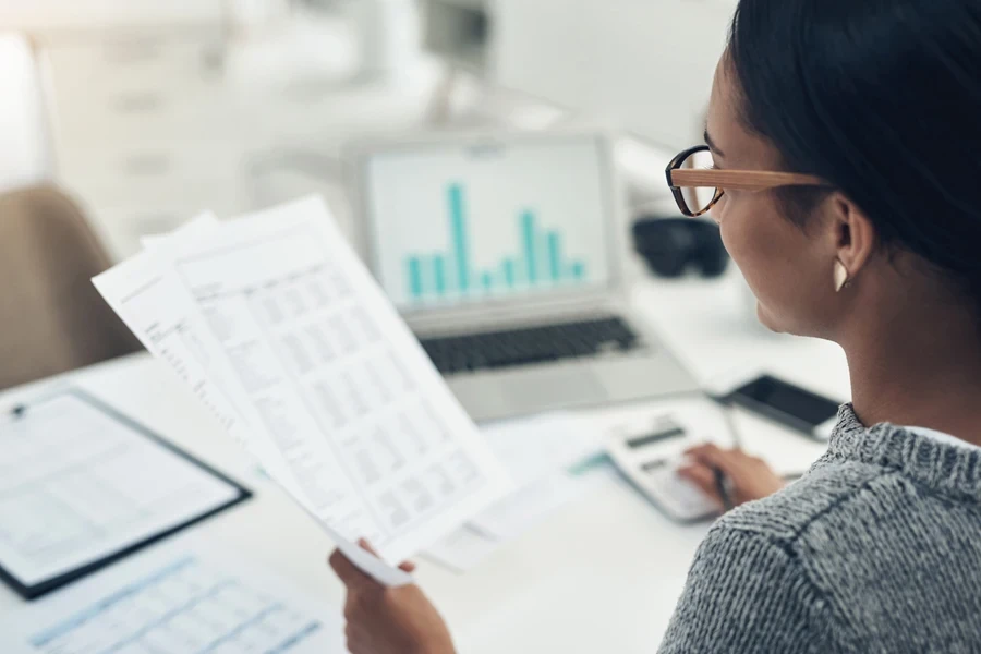 A businesswoman calculating revenue in an office