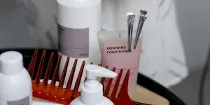 A collection of haircare products including shampoos, conditioners, and combs neatly arranged on a table
