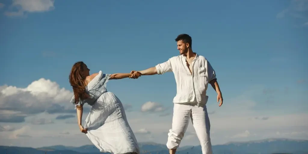 A joyful couple dancing in nature, enjoying a sunny summer day outdoors