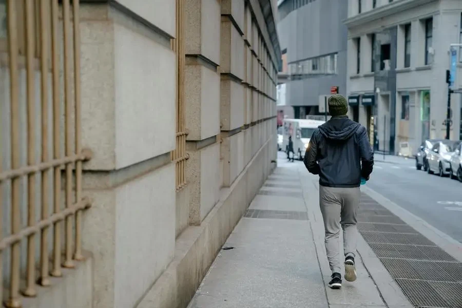 A man jogging along a city street, showcasing urban lifestyle and fitness