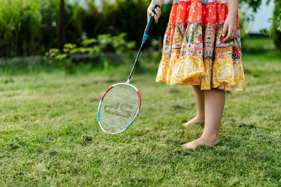 A person in a colorful dress playing badminton on a sunny summer day