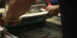A person working on a screen printer