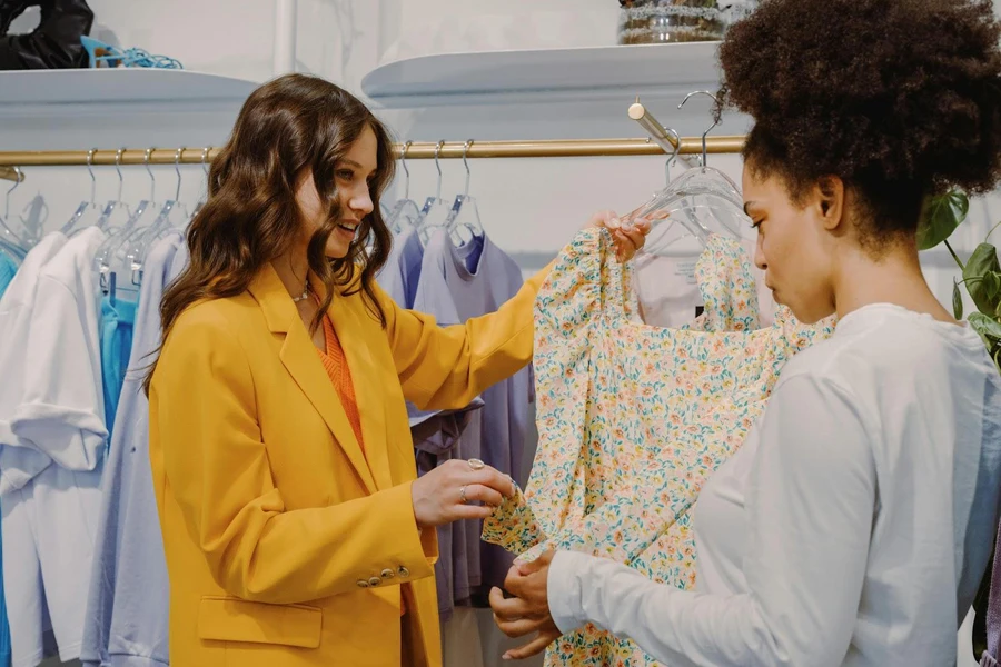 A personal stylist guiding a client in choosing the perfect dress