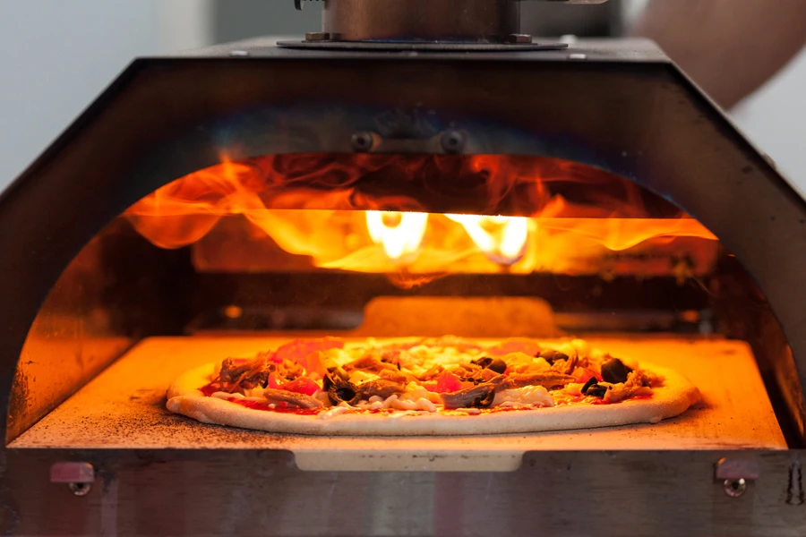 A pizza with favorite toppings baking in gas-powered oven