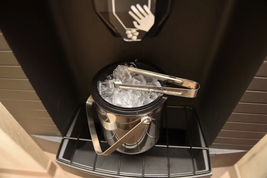 A silver tub in an ice machine filled with ice