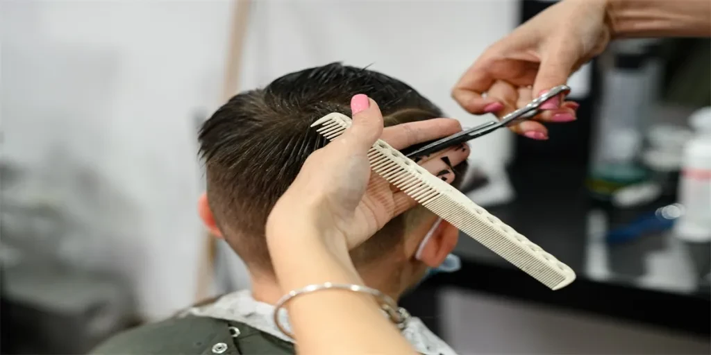 A teenager in a beauty salon gets a haircut