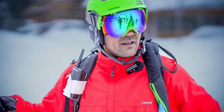 Adult skier with colorful goggles and safety gear ready for a winter adventure