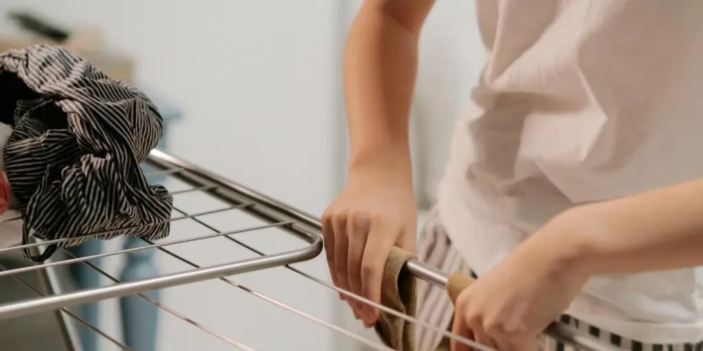 Asian woman folding clothes indoors in a casual setting, capturing everyday life