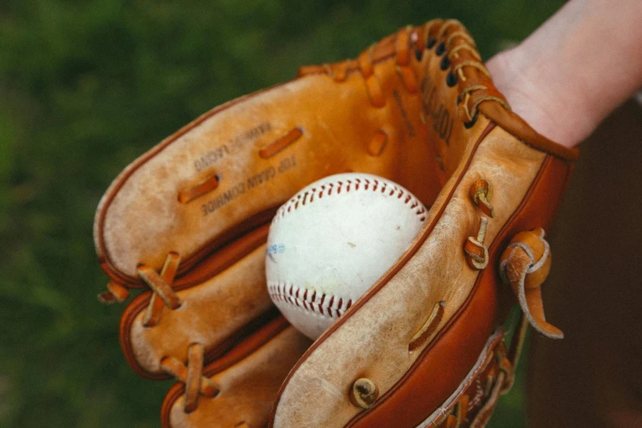 Baseball in hand and glove. Throw. Baseball equipment. Sport. The game. Advertising. Place for an inscription. The close plan