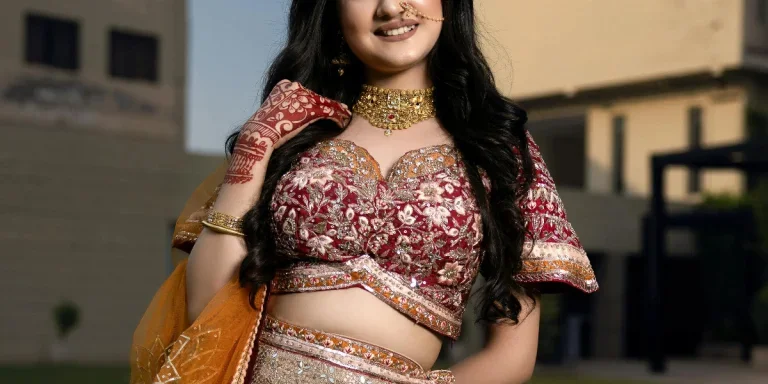 Beautiful Indian bride wearing traditional attire with intricate jewelry, posing outdoors in a festive setting by Vikash Singh