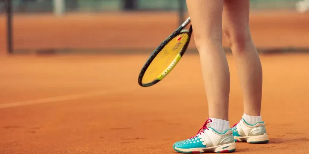 Beautiful female athlete with perfect body posing on tennis court