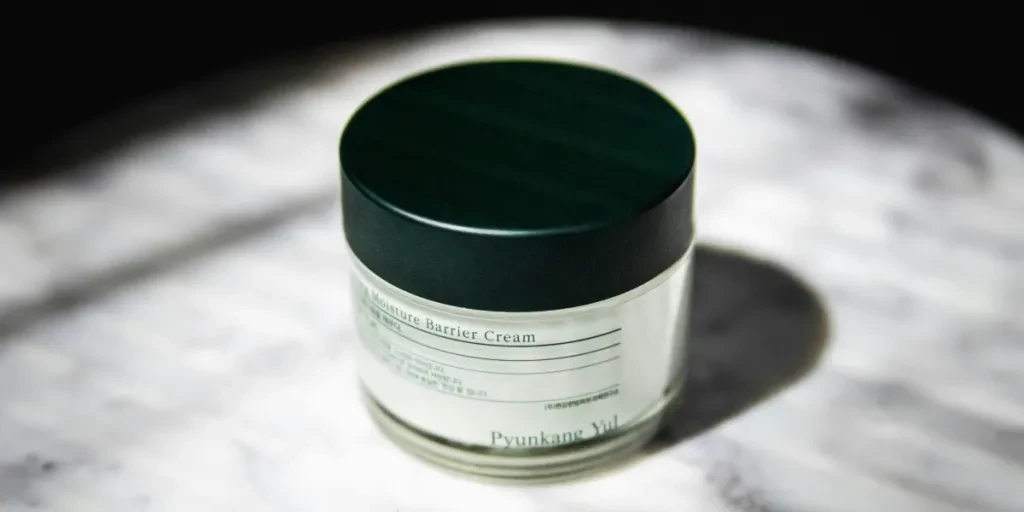 Close-up of a moisture barrier cream jar with stylish packaging on marble