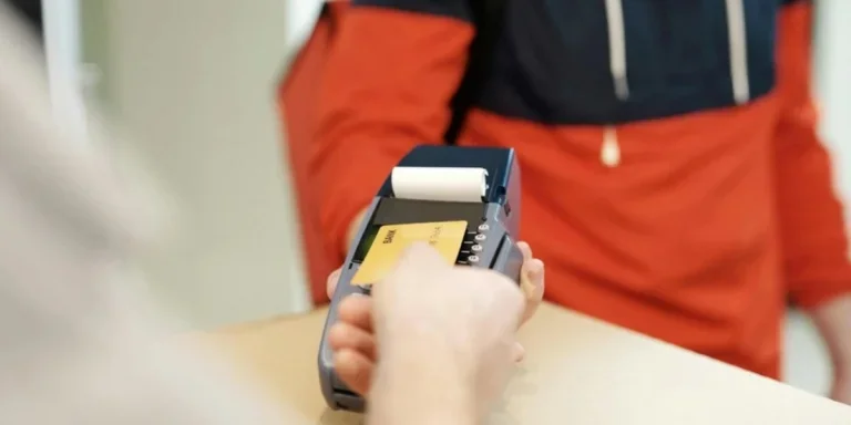 Close-up of a person getting receipt at the payment terminal