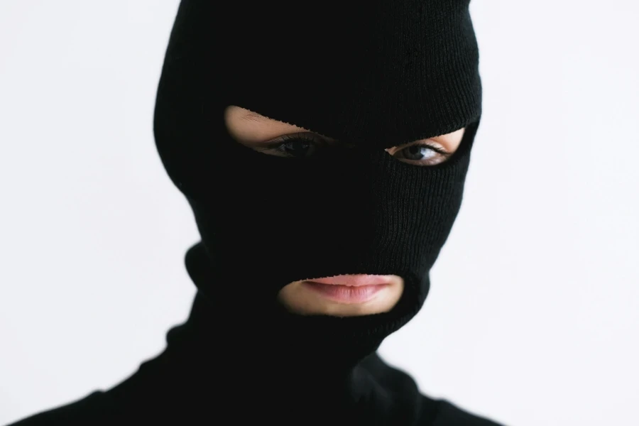 Close-up of a person wearing a black balaclava on a white background