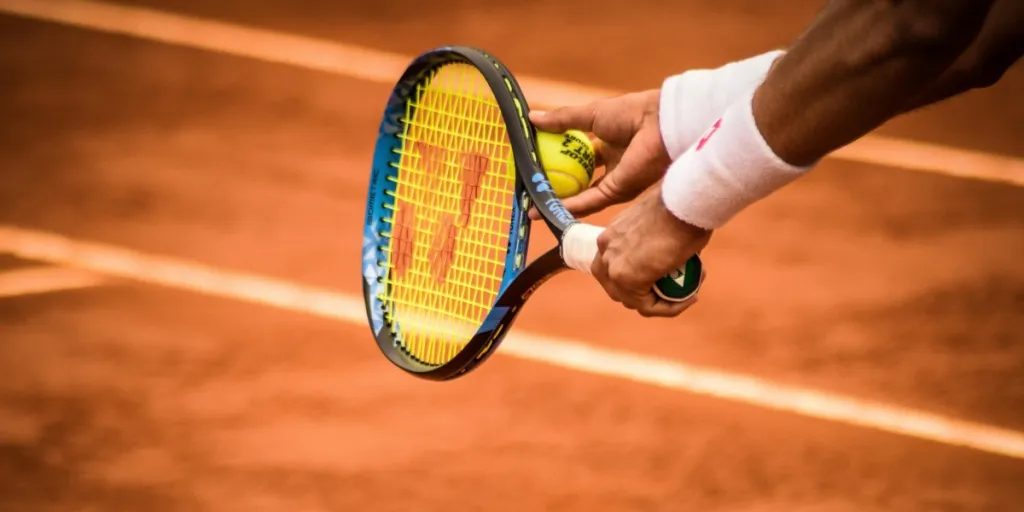 Close-up of a tennis player preparing to serve on a clay court in Montevideo