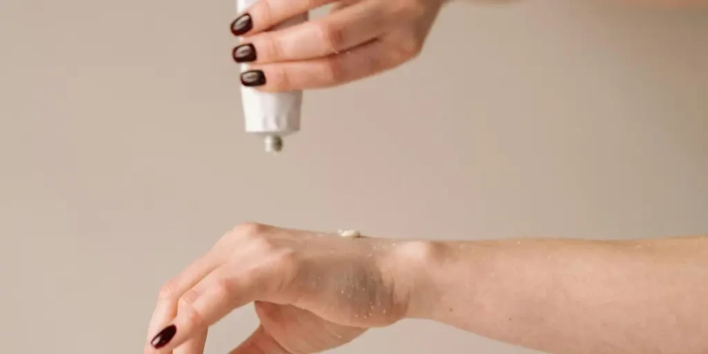 Close-up of a woman applying moisturizer to her hand for skincare routine