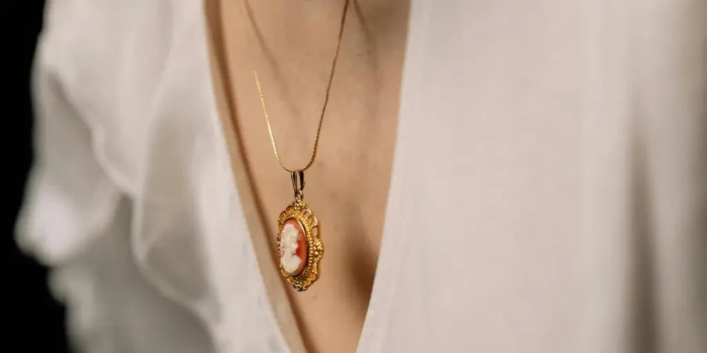 Close-up of a woman wearing a gold cameo necklace and white blouse, conveying elegance and sophistication