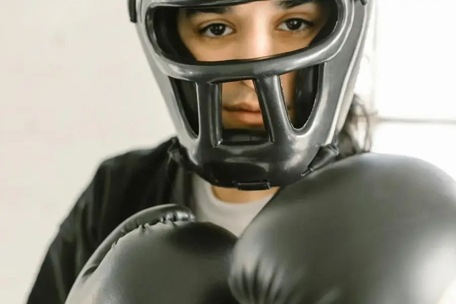 Close-up of a young martial artist wearing headgear and gloves, ready to sparct