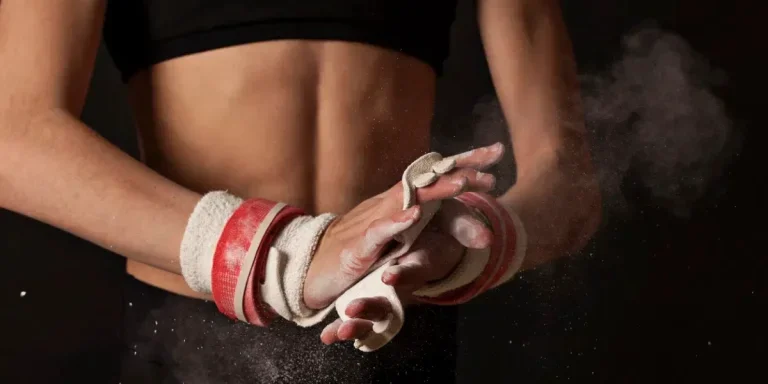 Close up of female gymnasts hands grips and cloud of chalk