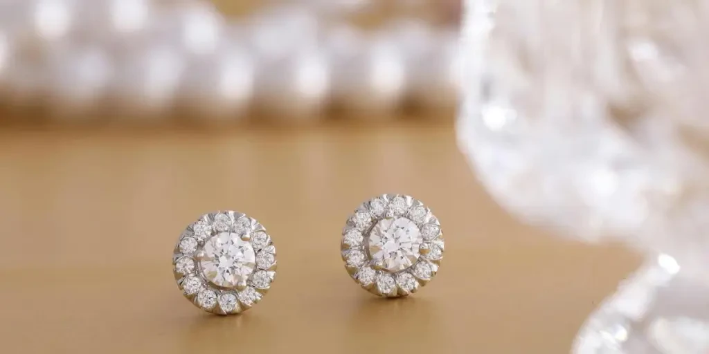 Close-up of round diamond earrings on a gold background, showcasing luxury and elegance