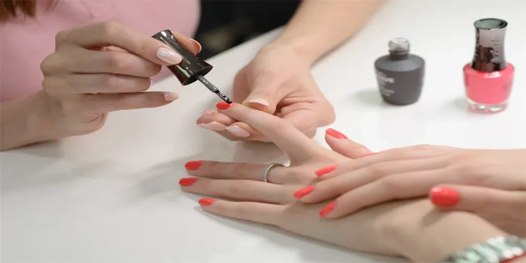 Closeup shot of a woman in a nail salon receiving a manicure by a beautician with nail file