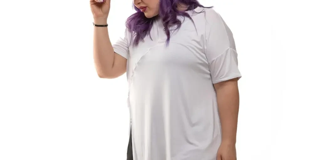 Confident plus size model in white tee and black pants showcases trendy streetwear with colorful hair