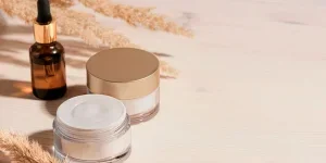 Kosmetisches Serum und Schönheitscremeprodukte mit trockenem Schilf oder Pampasgras auf Holzhintergrund