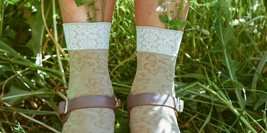 Creative display of flowers in socks worn with sandals in a sunny meadow