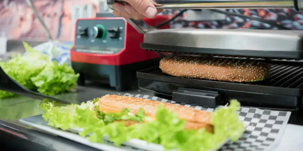 Delicious sandwich in preparation, on a plate full of fresh lettuce in a cafeteria